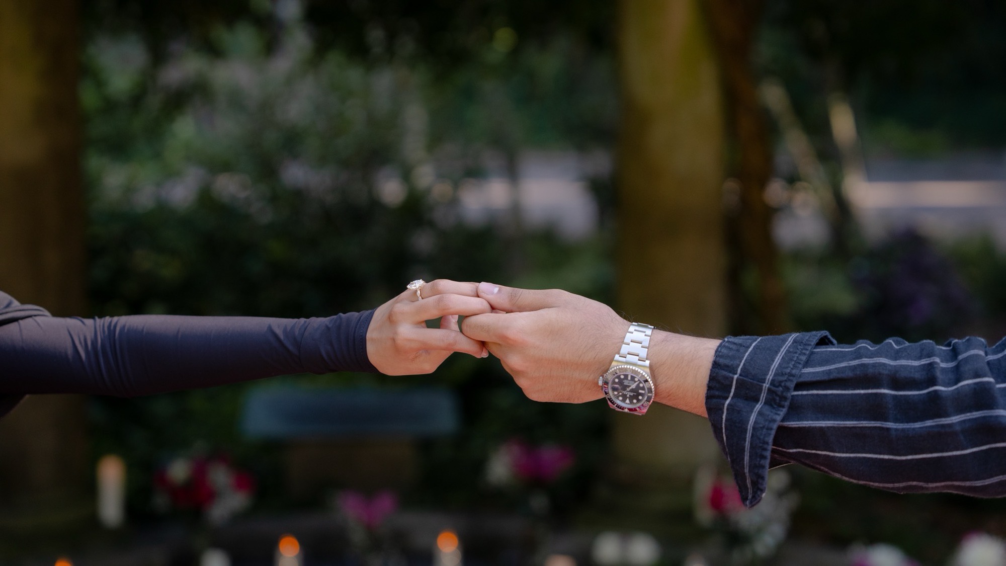 A couple's hands, wearing an Ehsaan & Co. marquise engagement ring